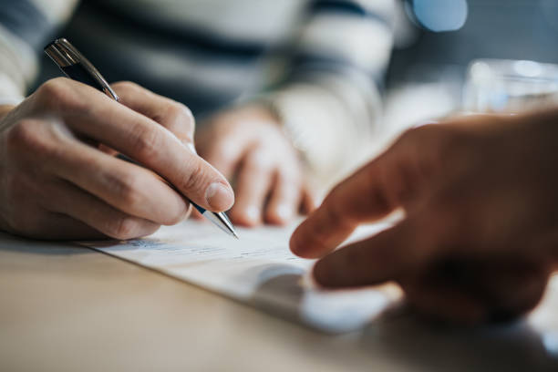 Description: Sign here please! Close up of unrecognizable man signing a contract while financial advisor is aiming at the place he need to sign. writing tips stock pictures, royalty-free photos & images